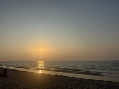 Soft golden sunset over a wide sandy beach